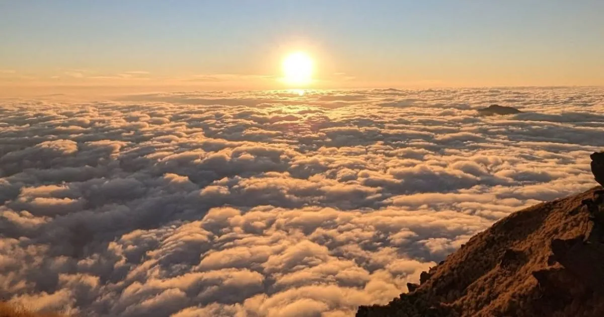 12 Best Places to Visit in Uttarakhand in October for Nature Lovers 9 Bright golden sun rising over a wide blanket of thick white fluffy clouds.
