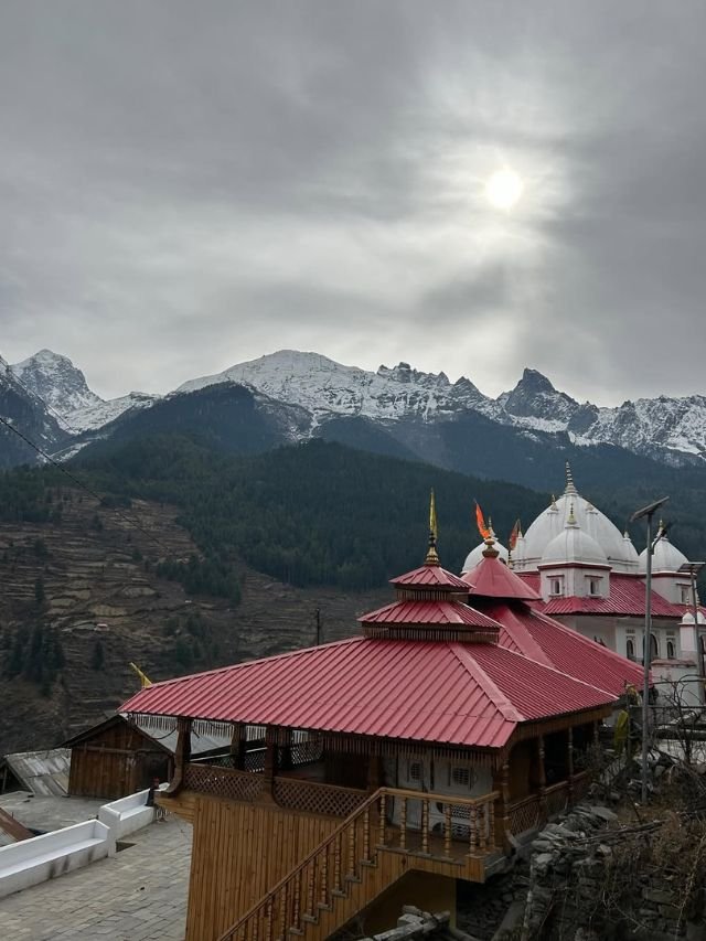 Visit Harsil Valley: How to Reach, Near Hotels, Best Time | Complete Travel Guide 14 Beautiful red roofed temple structures standing before snowy peaks near Harshil.