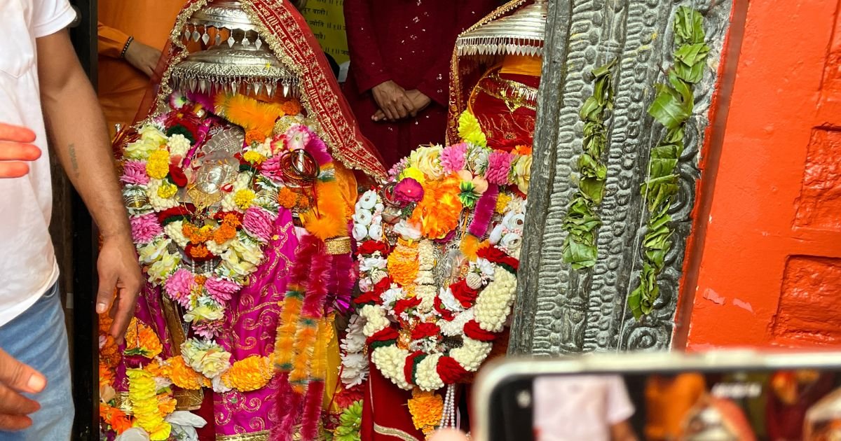 Maa Nanda Devi Badi Jaat Yatra 2026: Complete Travel Guide 1 Idols of Hindu deities decorated with bright flower garlands inside a temple.